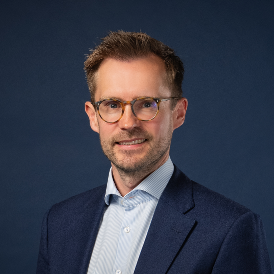 Porträt von Justus Quecke vor dunkelblauem Hintergrund